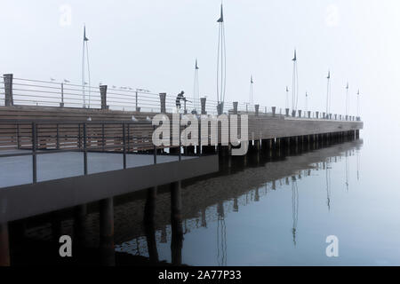 Sea pier in foggy weather Stock Photo