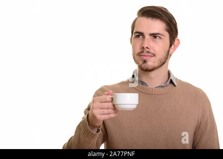 Portrait of young handsome bearded man drinking coffee Stock Photo