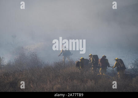Simi Valley, California, USA. 30th Oct, 2019. Firefighters work in Simi Valley, the United States, Oct. 30, 2019. An aggressive wildfire erupted Wednesday morning on the hillsides above Simi Valley, triggering a new round of evacuation in Southern California. The blaze, dubbed Easy Fire, was first reported around 6:15 a.m. local time, then spread to about 972 acres as of 9 a.m., Ventura County fire Capt. Brian McGrath told local KTLA news channel. Firefighters raced to protect the Ronald Reagan Presidential Library nearby as a thin wall of flames approached from hills. Credit: Xinhua/Alamy Liv Stock Photo
