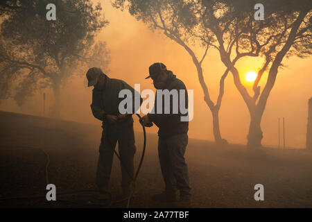 Simi Valley, California, USA. 30th Oct, 2019. Residents try to remove hidden fire near houses in Simi Valley, the United States, Oct. 30, 2019. An aggressive wildfire erupted Wednesday morning on the hillsides above Simi Valley, triggering a new round of evacuation in Southern California. The blaze, dubbed Easy Fire, was first reported around 6:15 a.m. local time, then spread to about 972 acres as of 9 a.m., Ventura County fire Capt. Brian McGrath told local KTLA news channel. Credit: Xinhua/Alamy Live News Stock Photo
