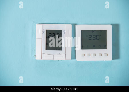 A Honeywell programmable thermostat to control the air conditioner and heater in a home. air conditioning system control unit on wall. White Stock Photo