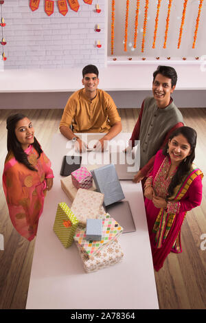 Employees standing around a table of gifts in office on the occasion of Diwali celebrations. Stock Photo