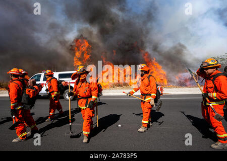 Simi Valley, United States. 30th Oct, 2019. Inmate firefighters contribute to the firefighting efforts during the Easy Fire near the Ronald Reagan Presidential Library in Simi Valley, California. The fire spread quickly due to strong Santa Ana winds with wind gusts reaching up to 70 mph in some areas. The National Weather Service issued a rare extreme red flag warning to the greater Los Angeles area. The fire prompted mandatory evacuations. Credit: SOPA Images Limited/Alamy Live News Stock Photo