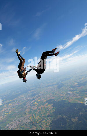 This skydiving team is training the head down formation together. Thereby they hold hand and having fun together with a speed of over 120mph. Stock Photo