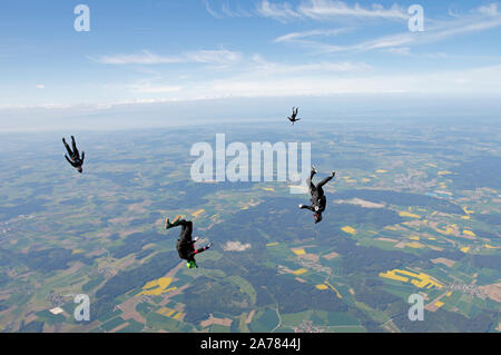 This skydiving team is training for a head down formation. It is fun for each jumper, but not as easy as expected to hold grips with a speed of 120mph Stock Photo