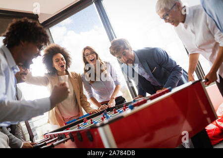Multiracial people having fun in office room, excited diverse employees enjoying activity at work Stock Photo