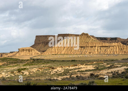 Steep mountains and a flock of sheep in the badlands Bardenas Reales Stock Photo