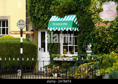 Exterior of quaint inviting sunlit ivy-clad Dalesman Café Tearoom & Sweet Emporium (white entrance door shut) - Gargrave, North Yorkshire, England, UK Stock Photo