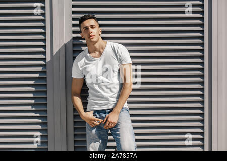 Outdoors Leisure. Stylish guy with eyeglasses up on head standing on the street posing to camera cool Stock Photo