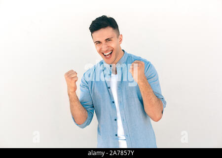 Outdoors Leisure. Stylish guy standing isolated on white hands in fists successful smiling cheerful Stock Photo