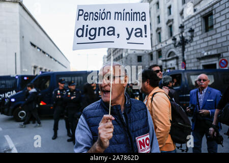 An old man holds a placard during the demonstration. Thousands of people gathered at Puerta del Sol to protest against precariousness and low pensions for elder people. Marches from Bilbao (northern Spain) and Rota (southern Spain) met at the country's capital to protest in front of Spanish Parliament. Stock Photo