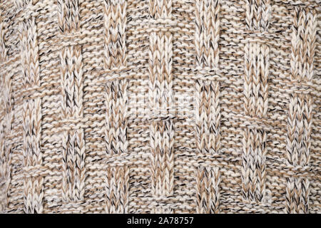 Real knitted fabric with ornamental pattern made of white brown black melange mixed yarn textured background Stock Photo