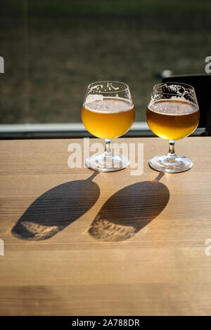 Two snifter glass with beer on the sun on the table Stock Photo