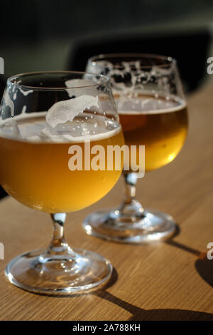 Two snifter glass with beer on the sun on the table Stock Photo