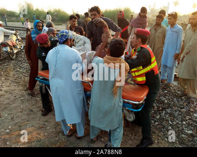 Rahim Yar Khan, Pakistan. 31st Oct, 2019. Photo taken with a mobile phone shows rescuers transferring an injured man after a passenger train caught fire in Rahim Yar Khan district of Pakistan's east Punjab province, Oct. 31. 2019. At least 65 people were killed and 14 others injured after a passenger train caught fire in Rahim Yar Khan district of Pakistan's east Punjab province on Thursday, a rescue official and local reports said. The death toll is feared to rise as rescue work continues to recover more bodies from the compartments gutted in the fire, Baqir Hussain, district em Credit: Xinhu Stock Photo