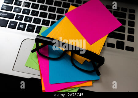 Colorful sticky notes with glasses on keyboard. Stock Photo