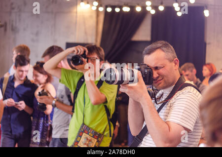 A group photographers at an event shooting a report using a digital cameras. Stock Photo