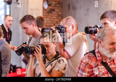 A group photographers at an event shooting a report using a digital cameras. Stock Photo