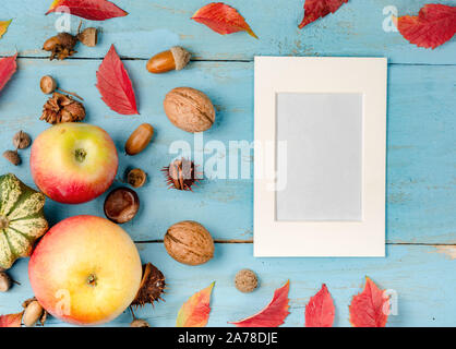 Autumn composition background. Autumn harvest on a blue wooden board with white photo frame for text . Top view, copy space, flat lay . Stock Photo