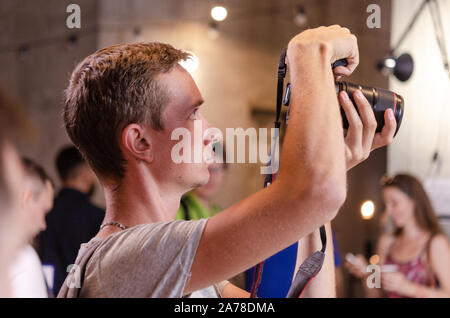 A photographer at an event shooting a report using a live view. Stock Photo