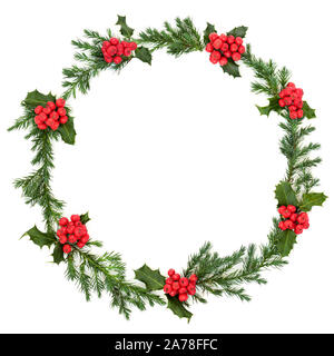 Holly berry and juniper leaf wreath for winter and Christmas on white background with copy space. Traditional symbol for the festive season. Stock Photo