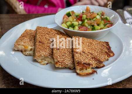 Toast with cheese and salad on a white plate in a cafe Stock Photo