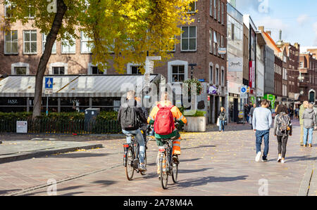 Eindhoven Netherlands, October 10, 2019. Rear view of people riding bikes, urban background, sunny autumn day Stock Photo