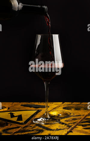 Serving a glass of red wine on a dark background Stock Photo