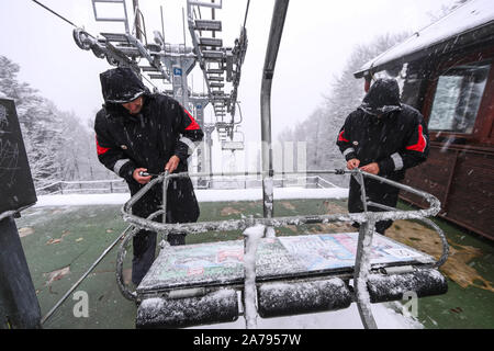 (191031) -- ZAGREB, Oct. 31, 2019 (Xinhua) -- Workers repair a snow-covered cable car at a ski resort on the Sljeme mountain in Zagreb, Croatia, Oct. 31, 2019. A sudden temperature drop and snowfall hit the area on Thursday following above-average temperatures for most of the month in the Croatian capital. (Igor Soban/Handout via Xinhua) Stock Photo