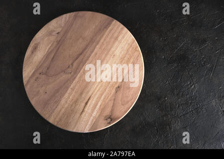 Round wooden cutting Board on the concrete to the abstract background. Stock Photo
