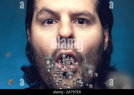 Man with open mouth exhaling or inhaling plastic particles. Environmental pollution and drug ingestion concept. Stock Photo