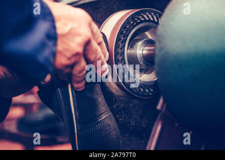 Shoemaker working in a shoe factory, finishing the soles of the shoes, at a machine. Stock Photo