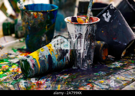 artist paintbrushes and acrylic colour in plastic cups close-up Stock Photo