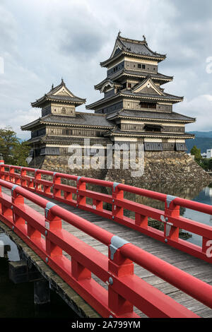 Matsumoto Castle (Crow Castle) with red bridge over the moat. Matsumoto Castle is one of Japan's most important historic castles. Stock Photo