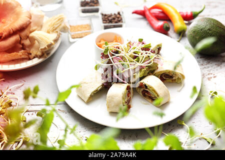 Tortilla rolls - filling with iceberg lettuce, avocado, dried tomato and caramelized oyster mushroom with mayonnaise sauce. Stock Photo