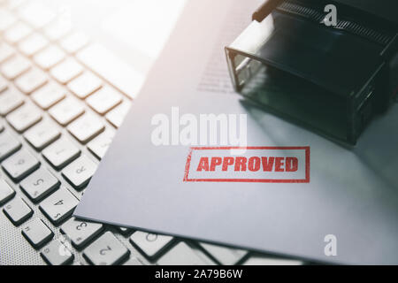 document with approved stamp on computer keyboard Stock Photo