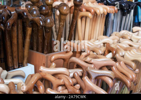 Wooden walking sticks are made for the elderly and disabled. They are patterned and filmed in front of the store. Stock Photo