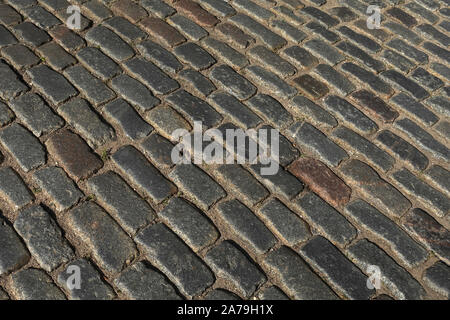Old dark paving cobblestone outdoors as background diagonal view close up Stock Photo