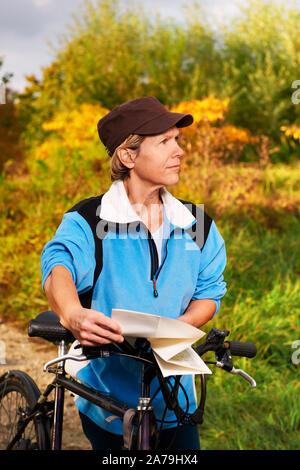 Senior cyclist checks the route on the road map Stock Photo