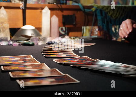 Boothbay Harbor, ME / USA - October 20, 2019: Client picks cards from the spread during a tarot reading Stock Photo