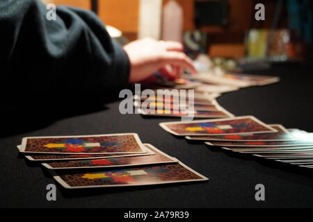 Boothbay Harbor, ME / USA - October 20, 2019: Client picks cards from the spread during a tarot reading Stock Photo