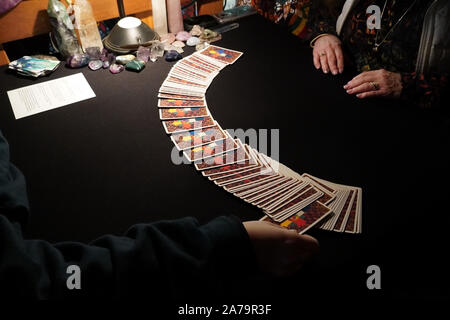 Boothbay Harbor, ME / USA - October 20, 2019: Client picks cards from the spread during a tarot reading Stock Photo