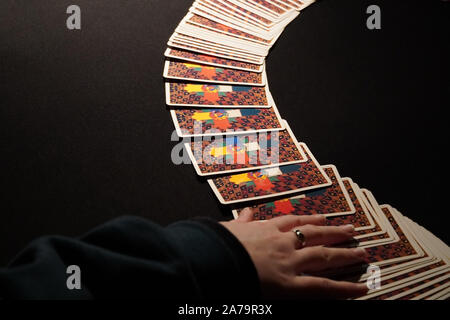 Boothbay Harbor, ME / USA - October 20, 2019: Client picks cards from the spread during a tarot reading Stock Photo