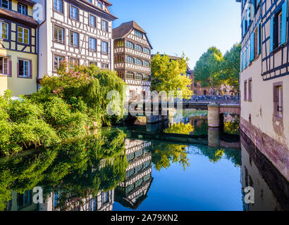 The Pont du Faisan on the river Ill canal in the Petite France quarter in Strasbourg, France, lined by half-timbered houses reflecting in the water. Stock Photo