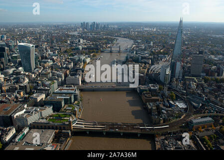 An aerial view looking east down the River Thames with the Shard and London Bridge.