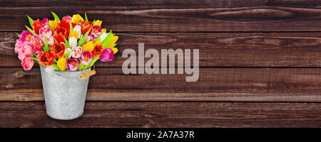 Spring bouquet in a zinc bucket with wooden background Stock Photo
