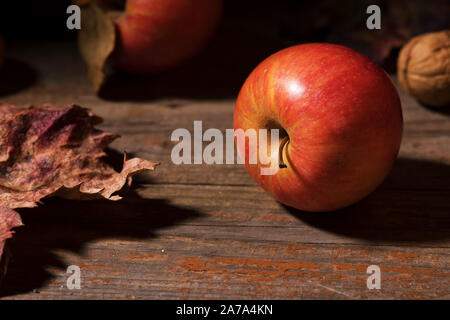 Fall apples and colorful leaves on old rustic wooden boards. Autumn Thanksgiving day background. Beauty harvest autumn concept. Fall composition Stock Photo