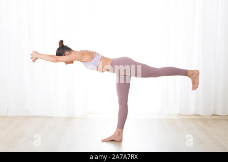 Premium Photo  Balancing stick pose. tuladandasana. side view is portrait  of beautiful young woman doing yoga or gymnastics on white background.