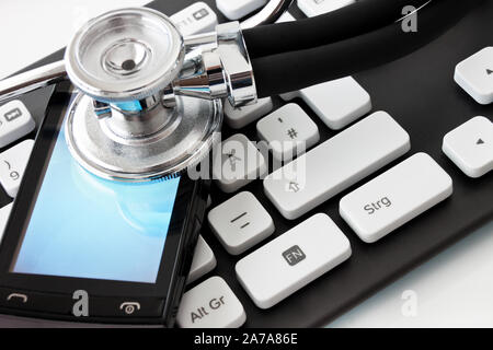 Keyboard with stehoscope and smartphone on white background close up Stock Photo
