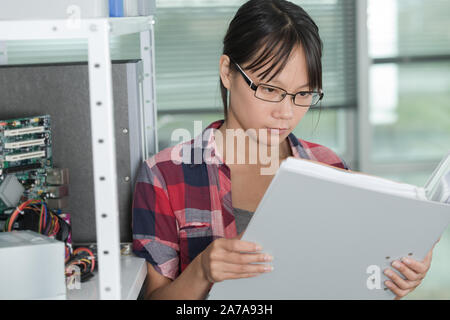 female technician working on laptop in data center Stock Photo